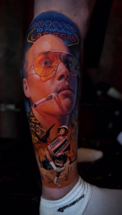 Fear and Loathing in Las Vegas tribute with yellow aviator glasses, cigarette holder and the Las Vegas sign, colour tattoo on a calf.